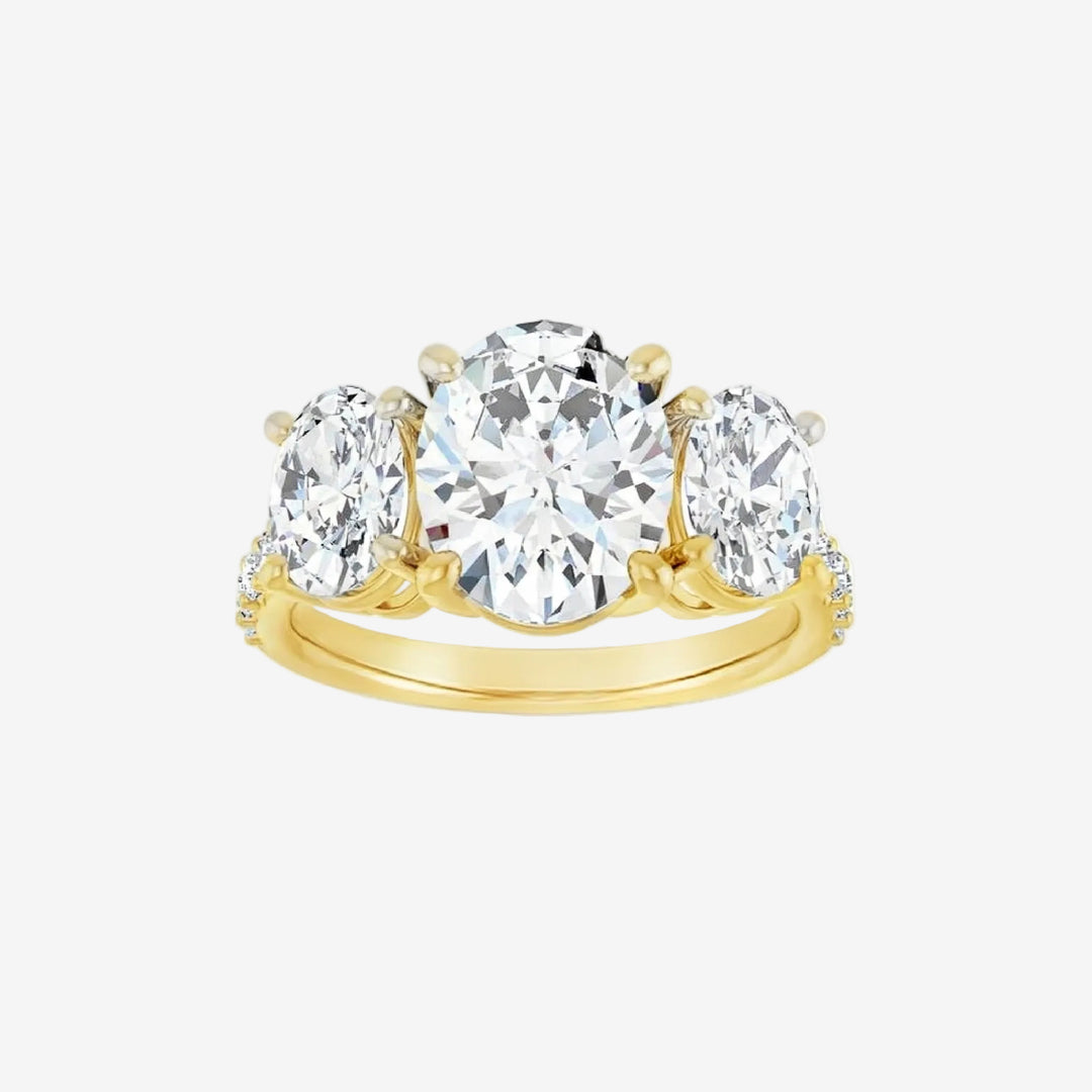 Gold ring with three clear gemstones on a white background