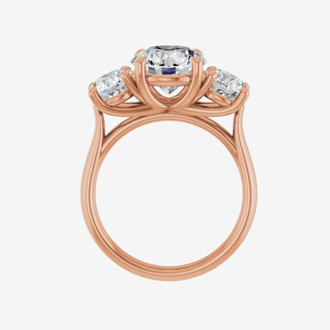 Rose gold ring with central round diamond and two side round diamonds on a white background