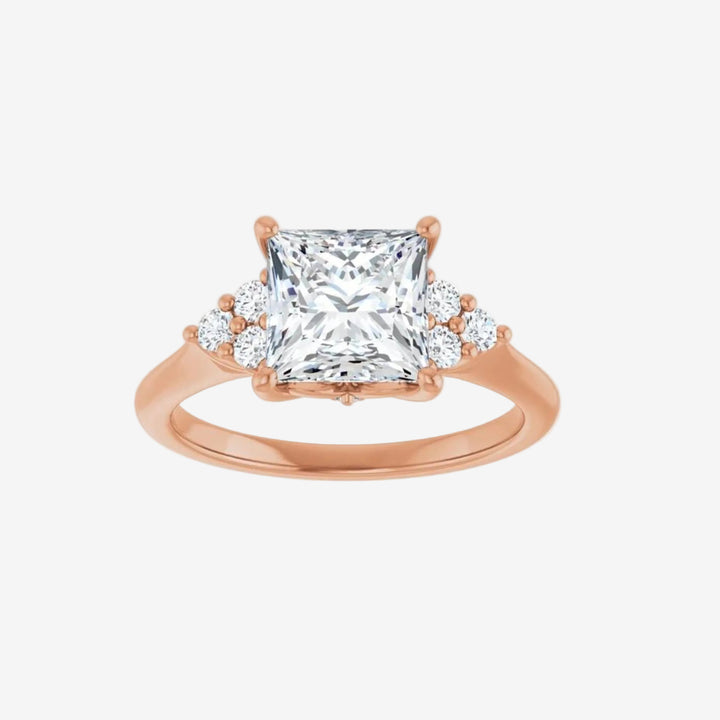 Rose gold ring with a large diamond and smaller diamonds on the sides.